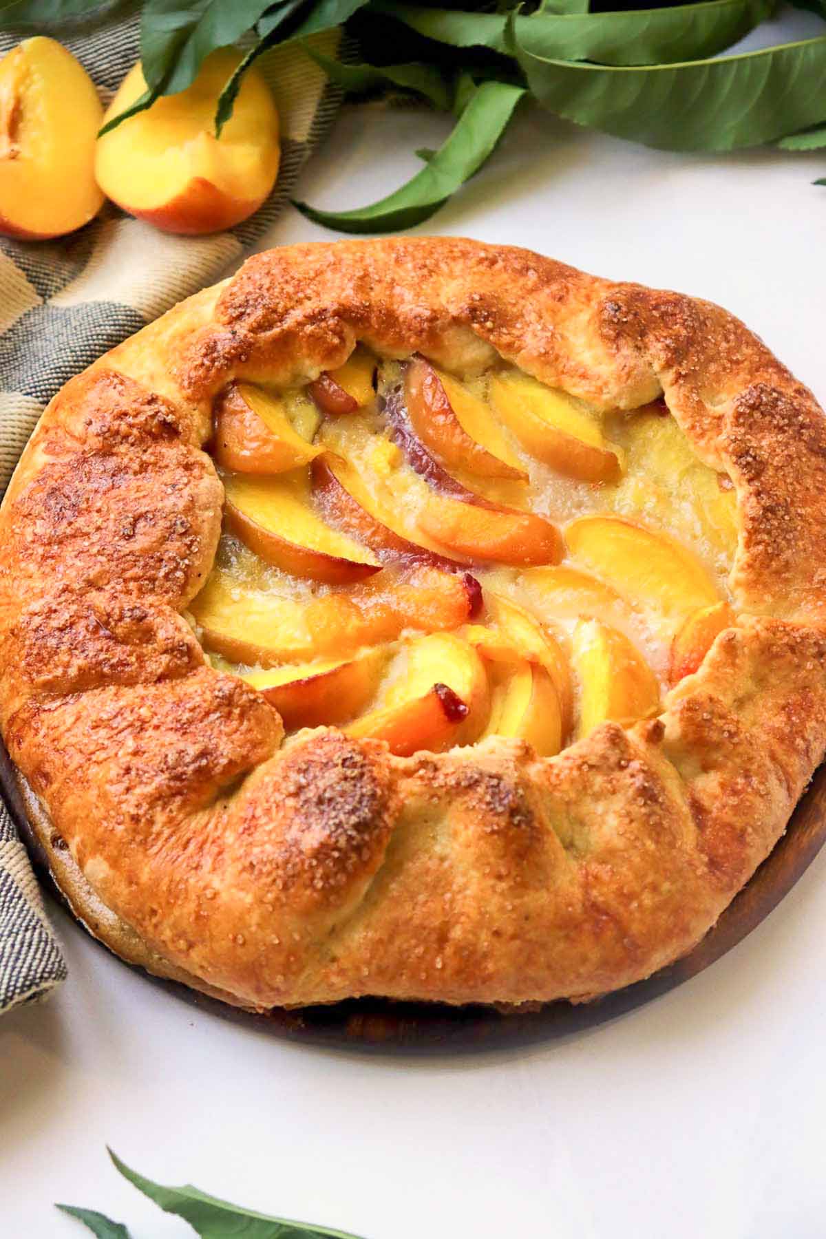 baked peach galette on a cutting board.