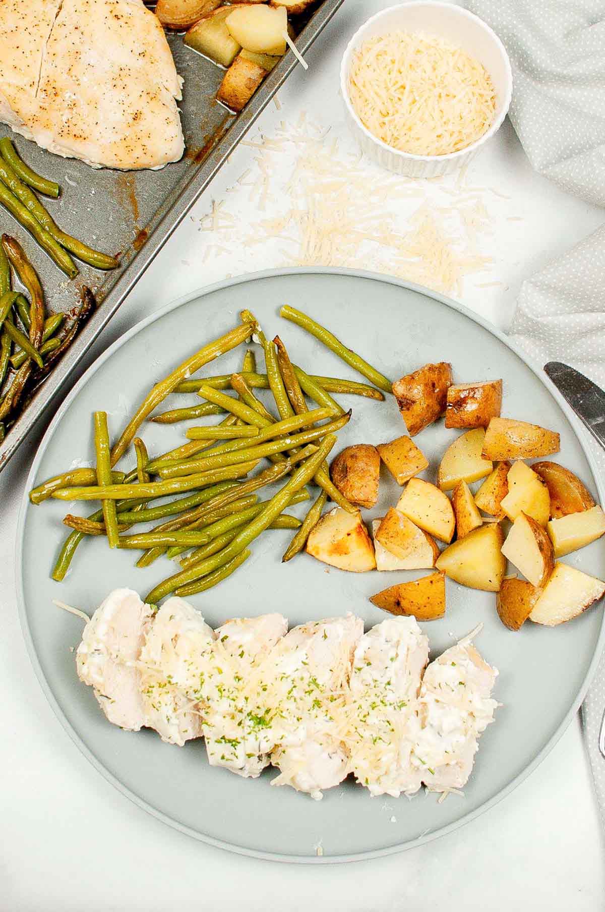 top view of chicken, potatoes and green beans on a plate.