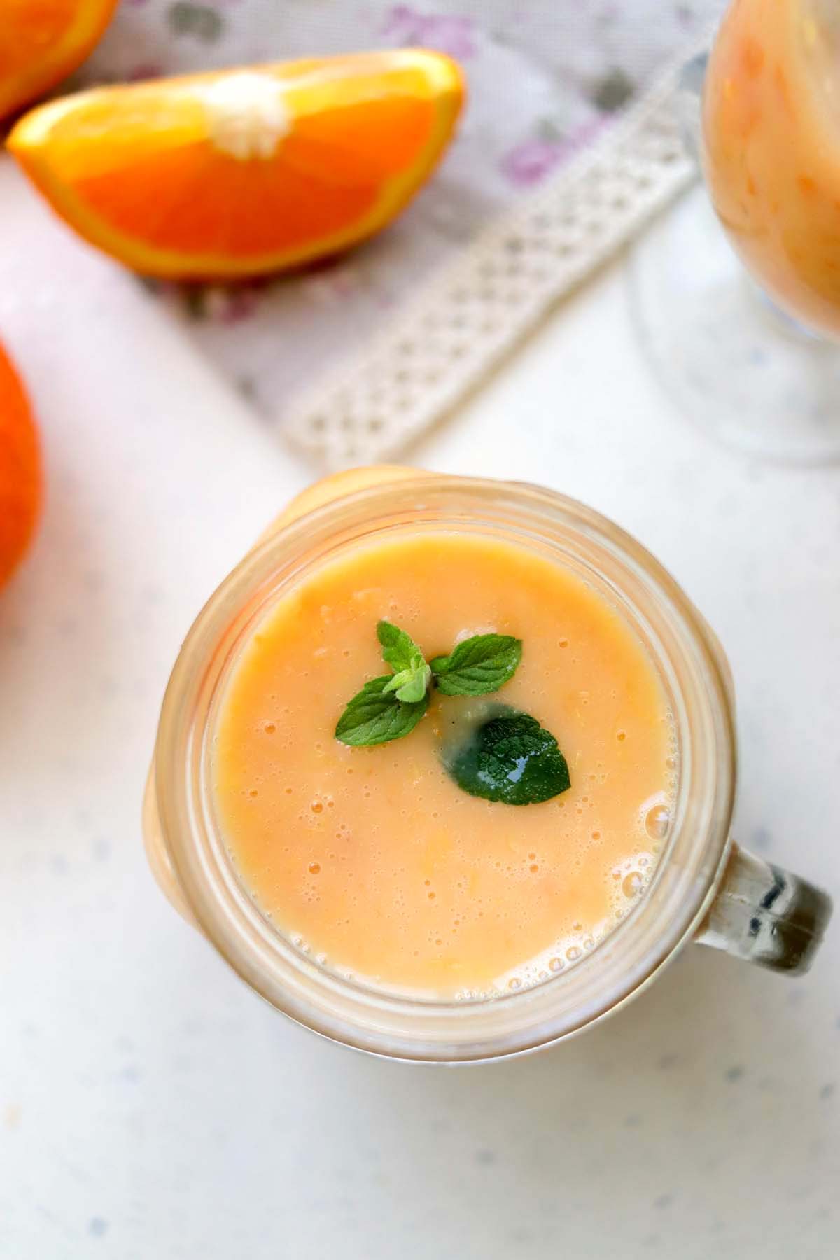 Orange drink topped with a sprig of mint.