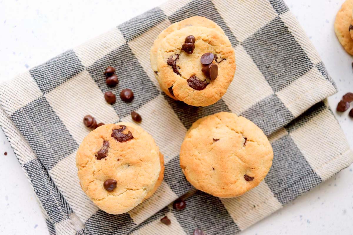 Three stacks of cookies on a kitchen towel.