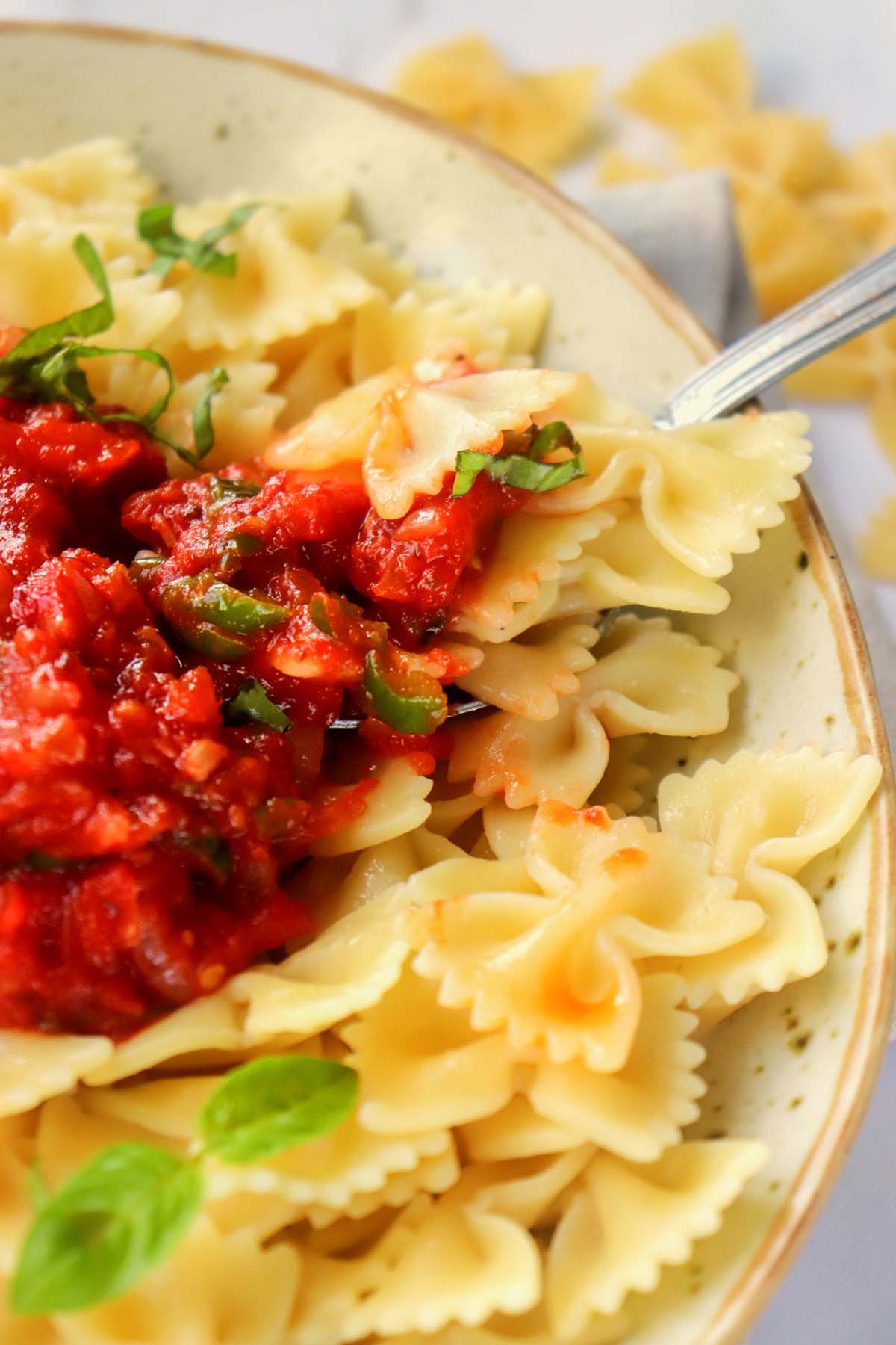 marinara sauce over pasta with a fork.