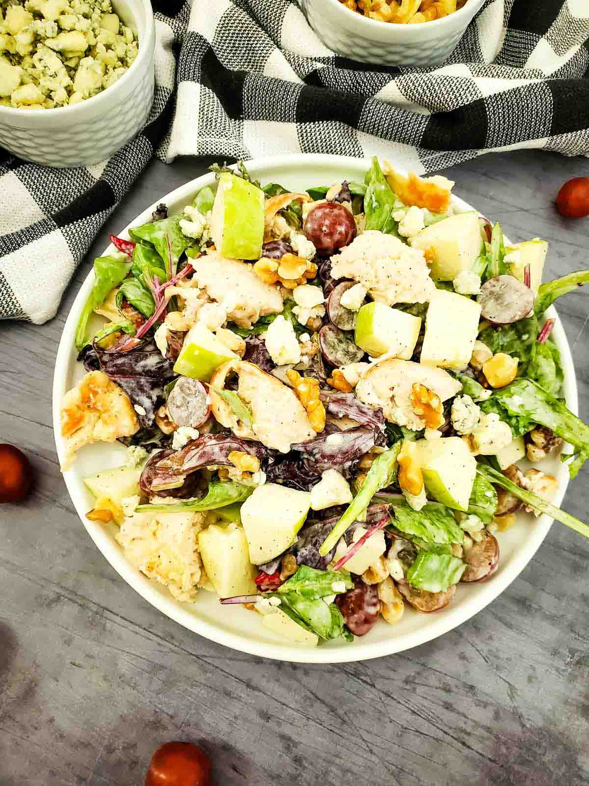 Chicken salad on a plate next to a kitchen towel.