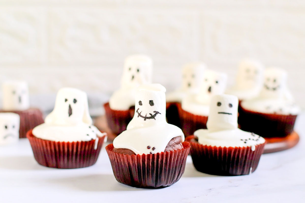 Ghost cupcakes set on a table.