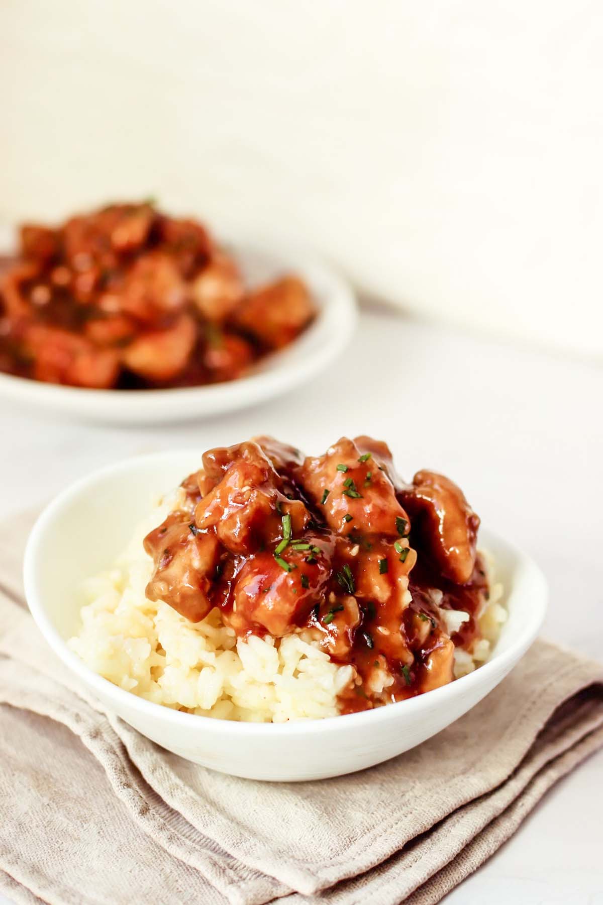 Chicken in a bowl served over rice.