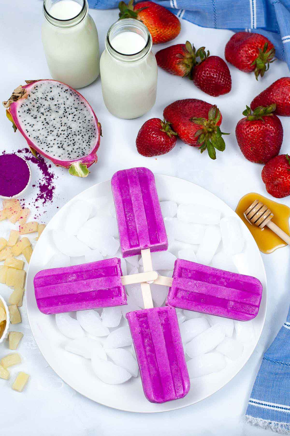 Popsicles on a plate next to the ingredients.