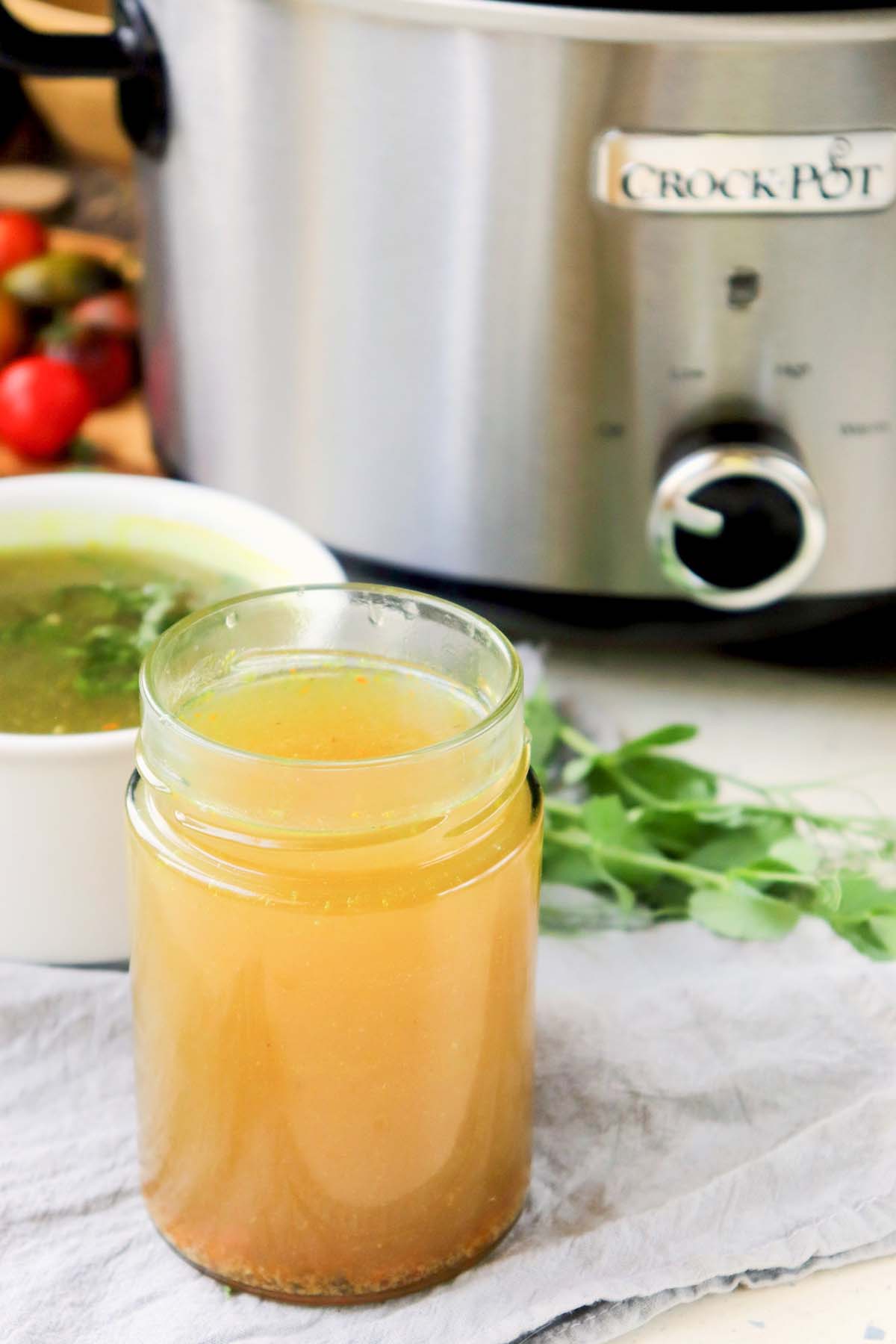 Stock in a jar in front of the Crock Pot.