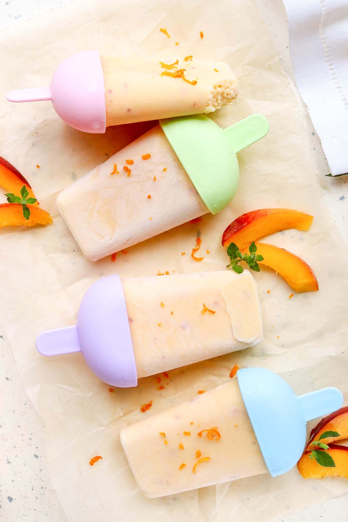 Four popsicles on parchment paper.