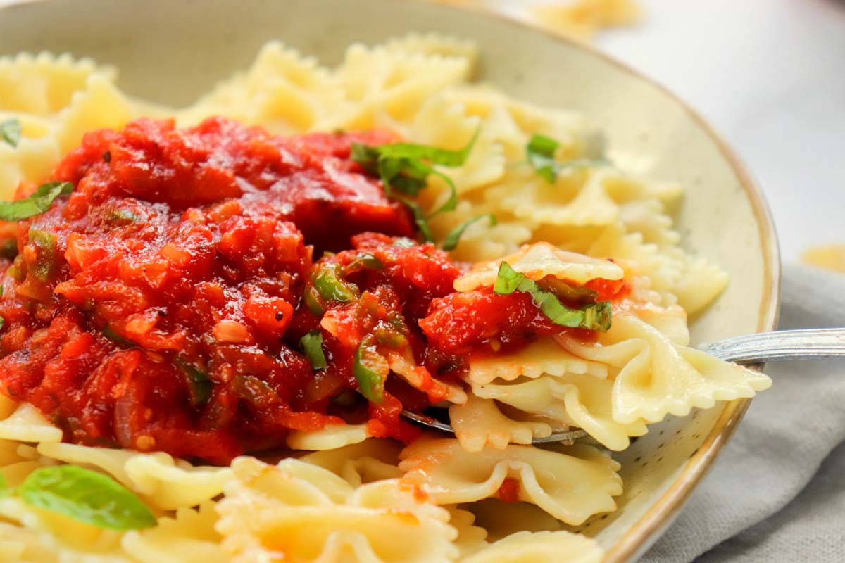 close up view of marinara sauce over pasta.