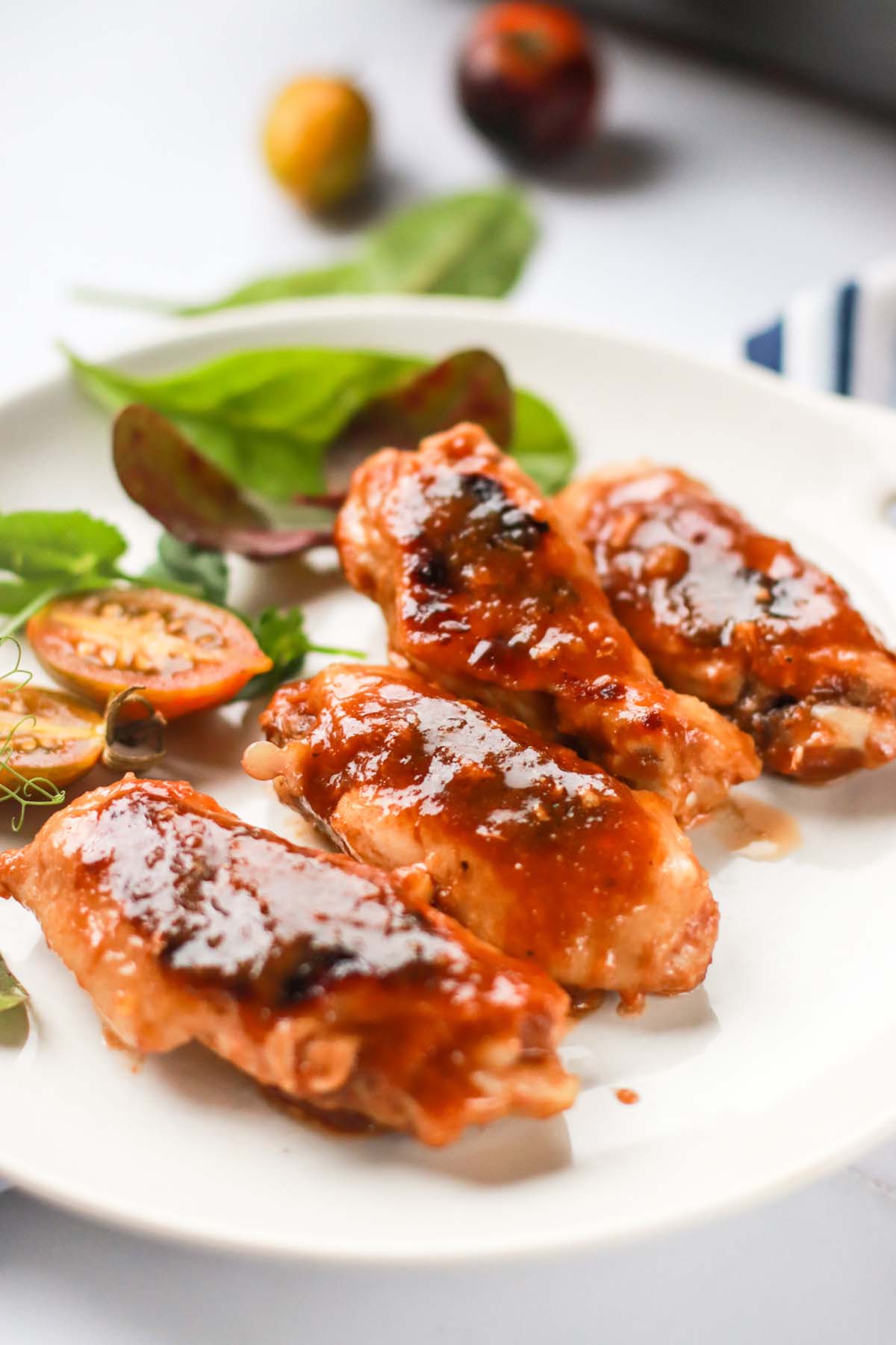 Four bbq wings on a plate.