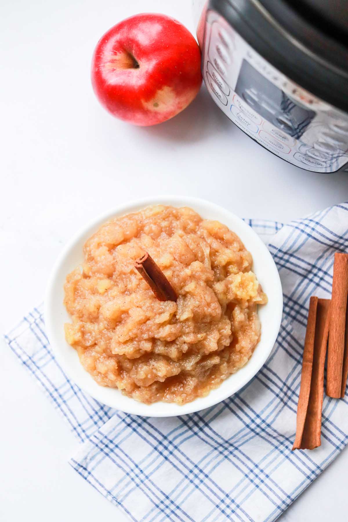 Applesauce in a bowl set on a kitchen towel.