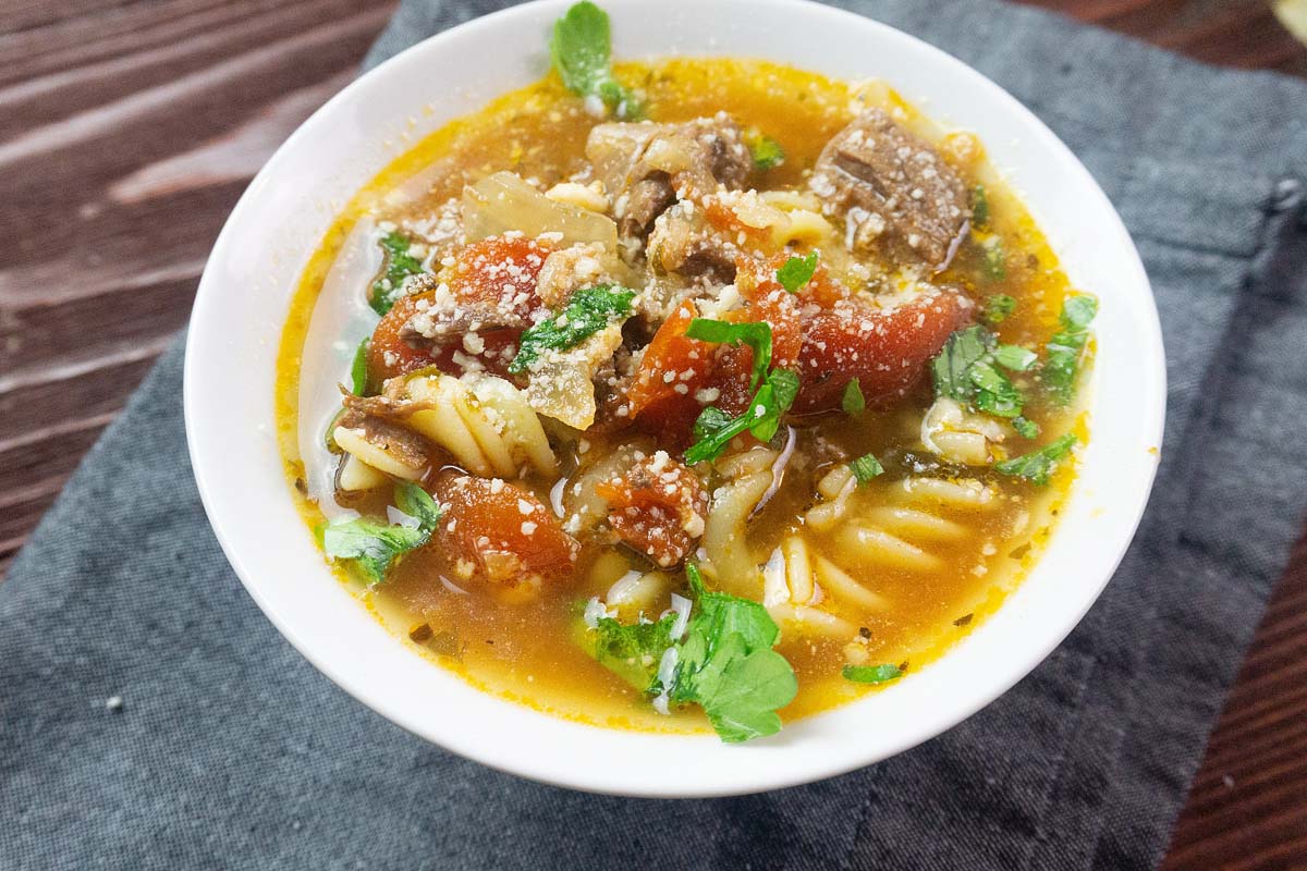 Beef stew with pasta in a white bowl.