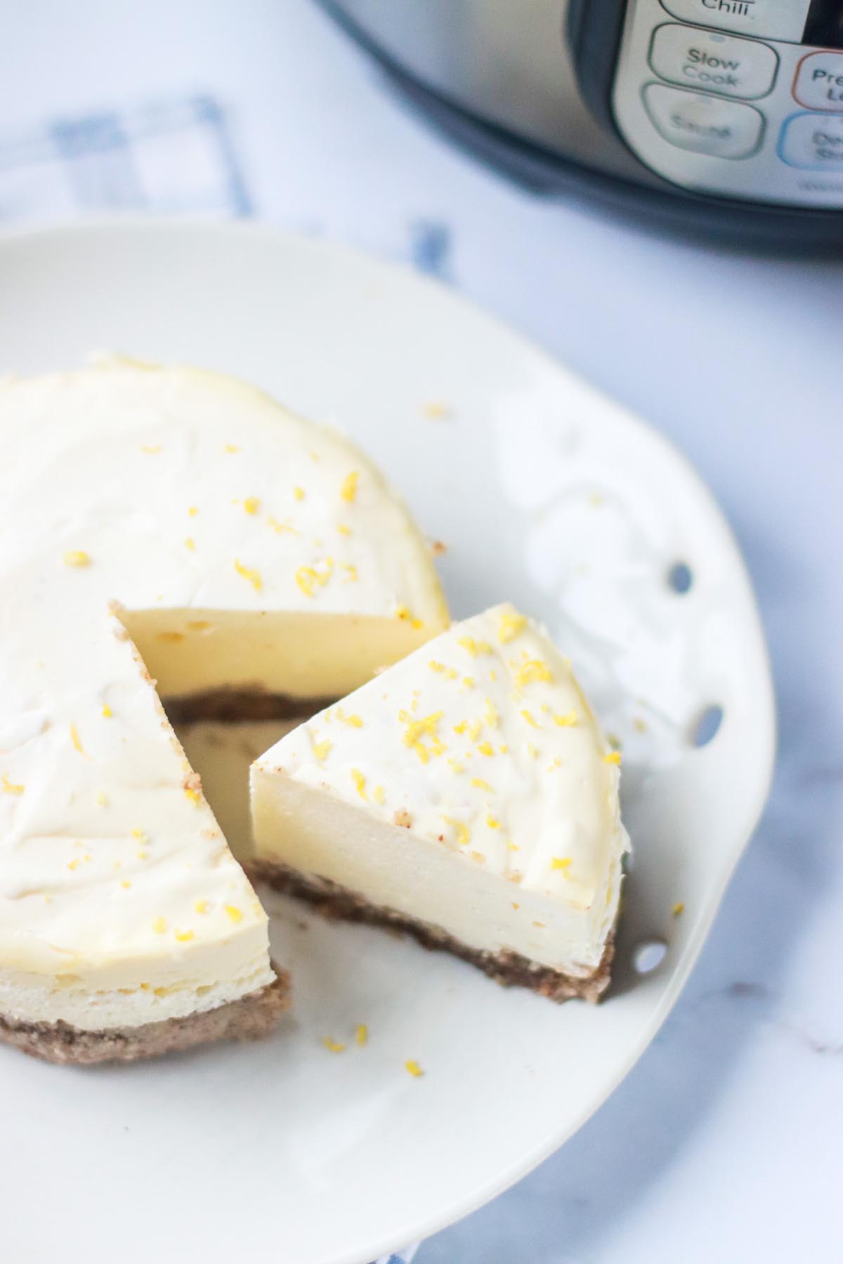 A slice of cheesecake taken out of a whole cheesecake.