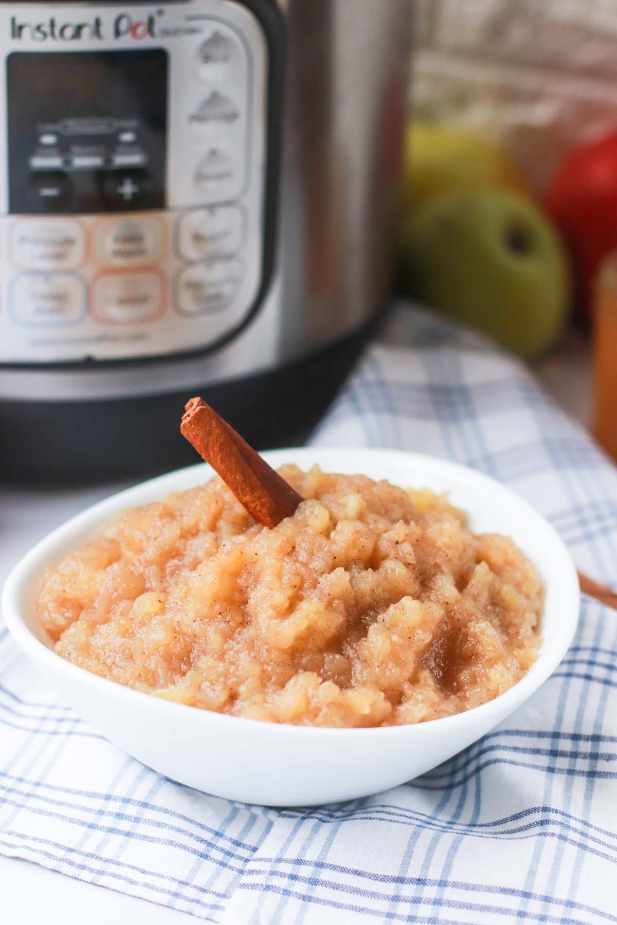 Applesauce in a bowl in front of the Instant Pot.