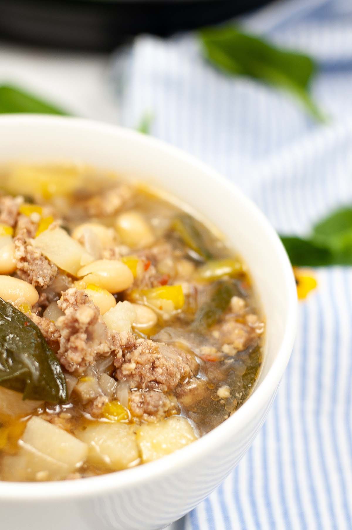 Sausage soup in a white bowl.