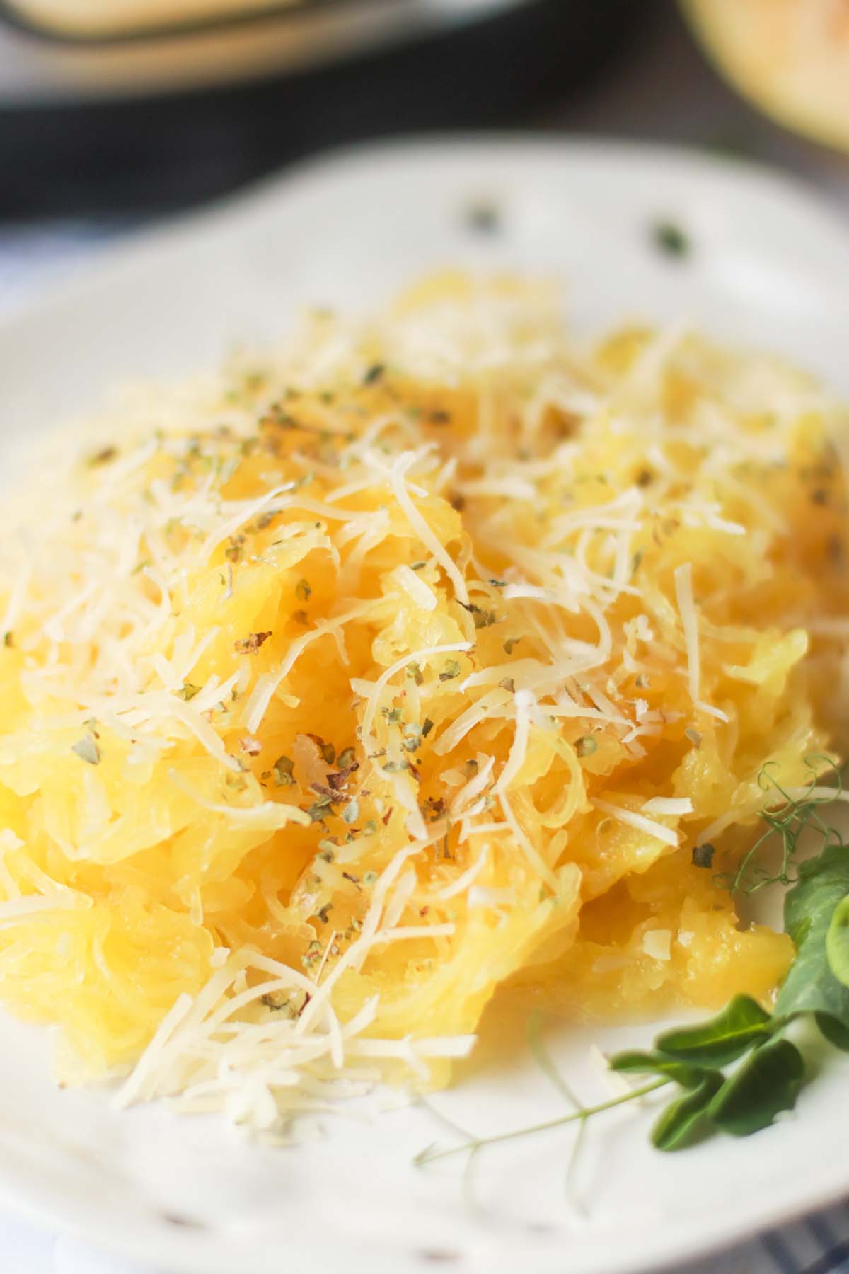 Spaghetti squash on a plate topped with parmesan cheese.