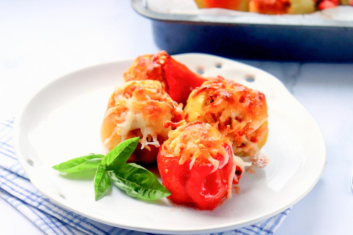 Four stuffed peppers on a plate.