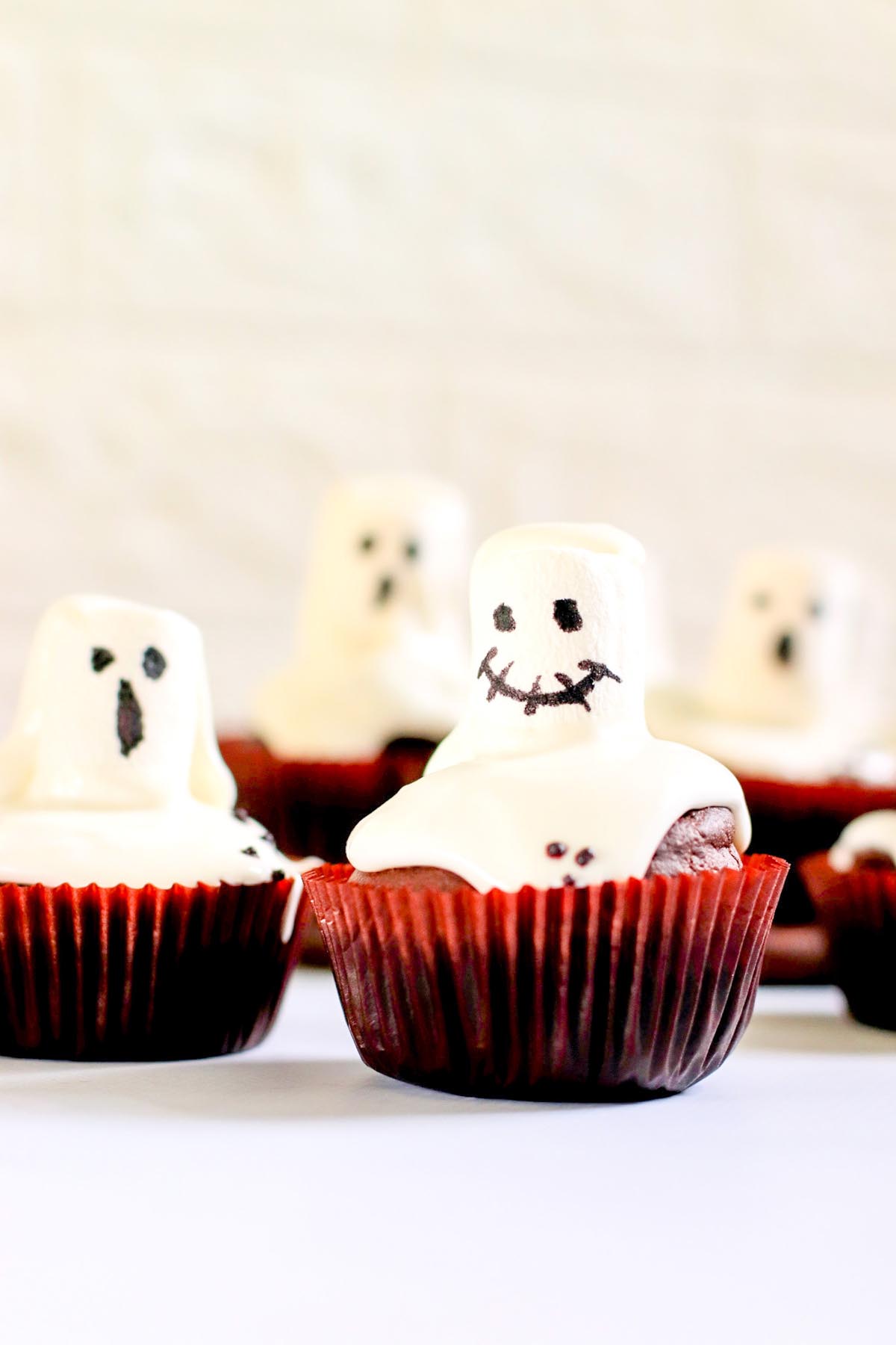 ghost cupcakes on a white table.