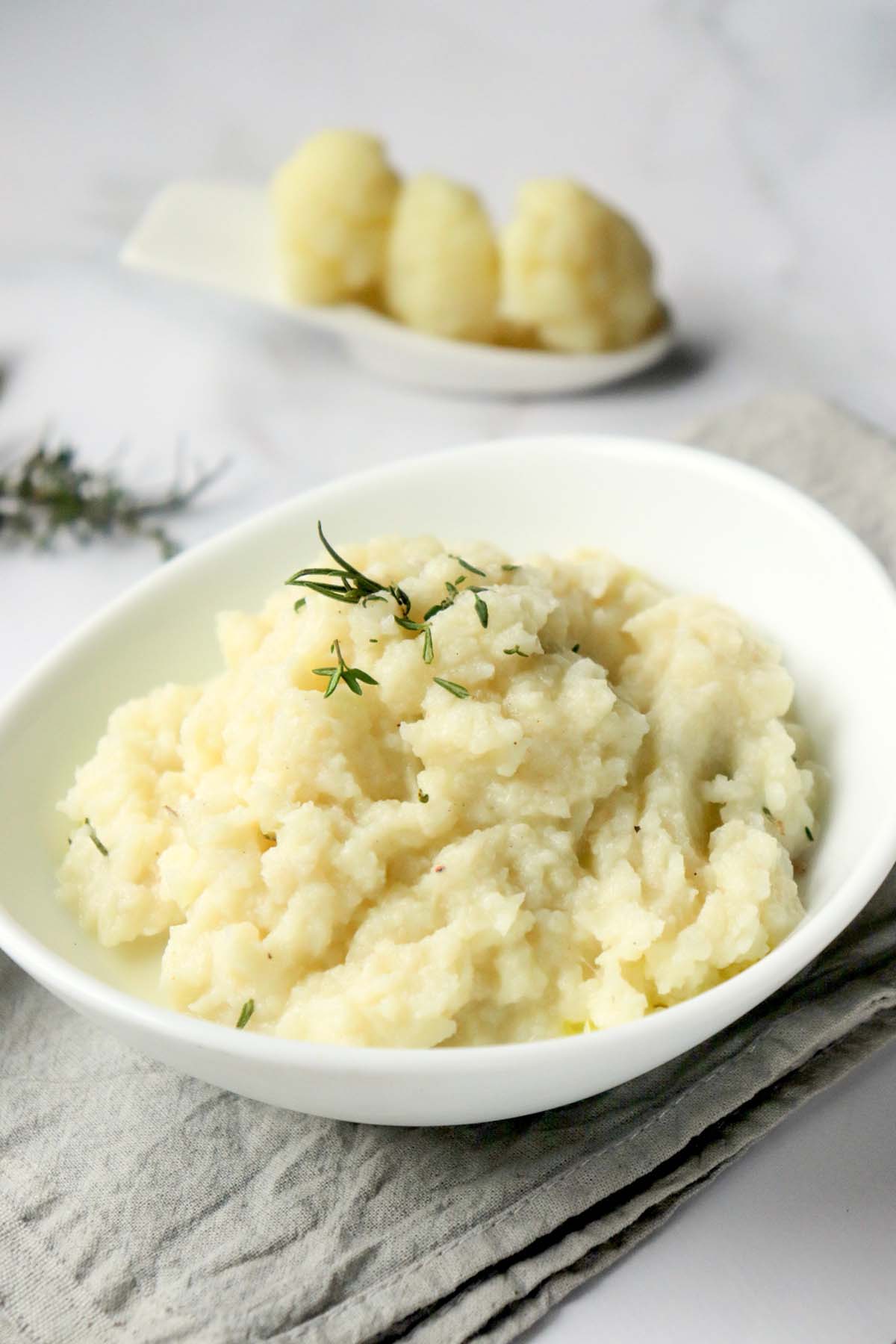 Mashed cauliflower in a white bowl.