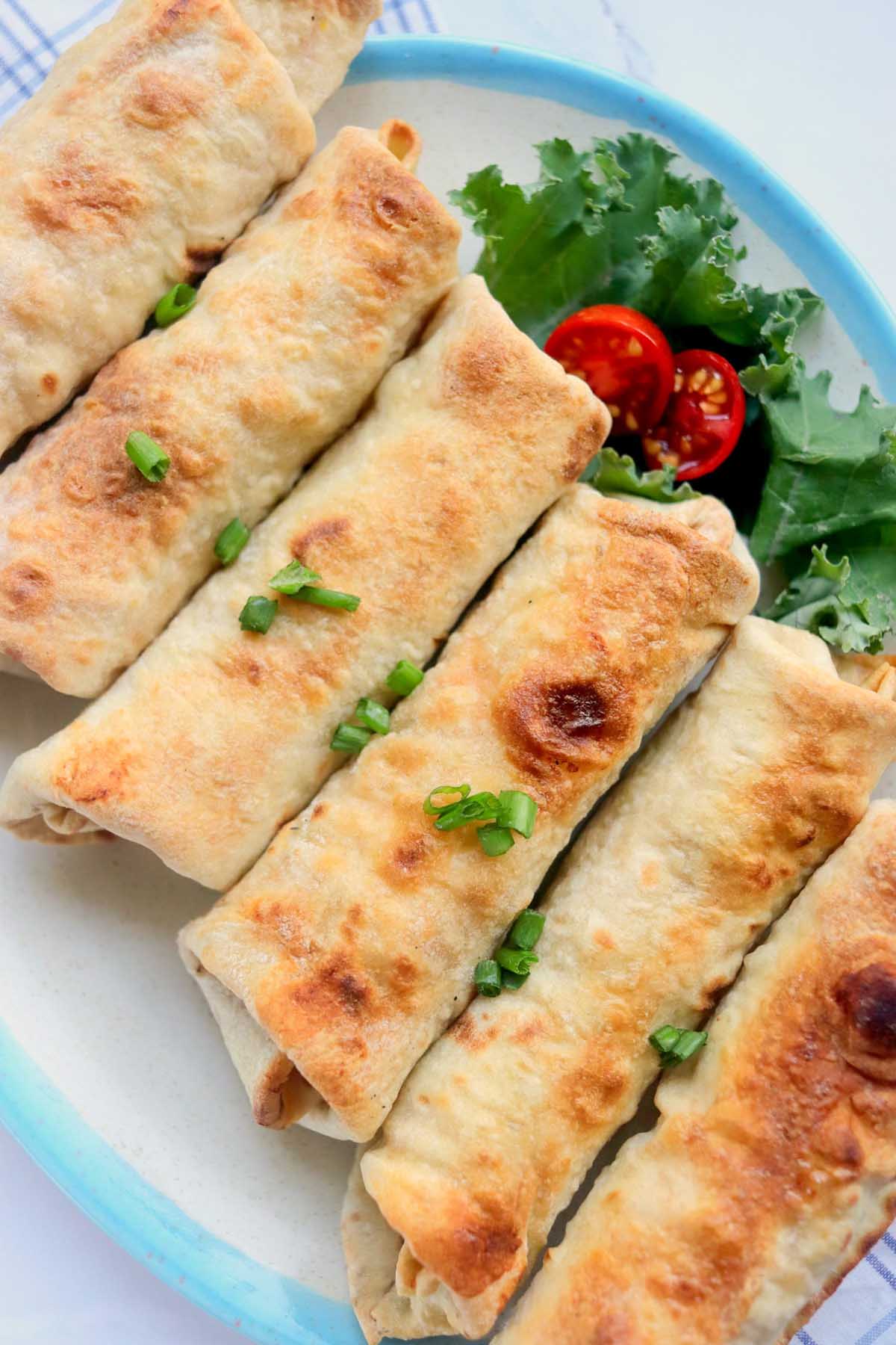 Baked chimichangas on a plate.