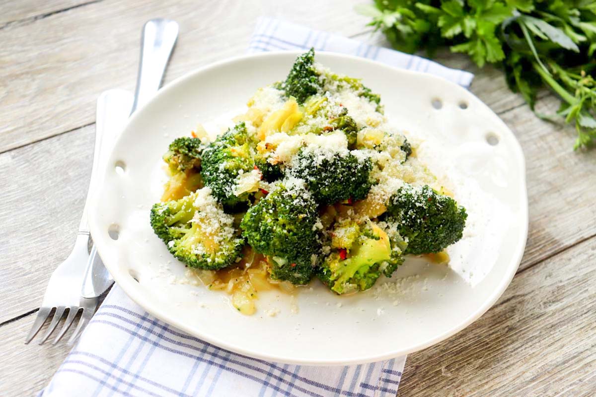 Broccoli on a plate set on a kitchen towel.