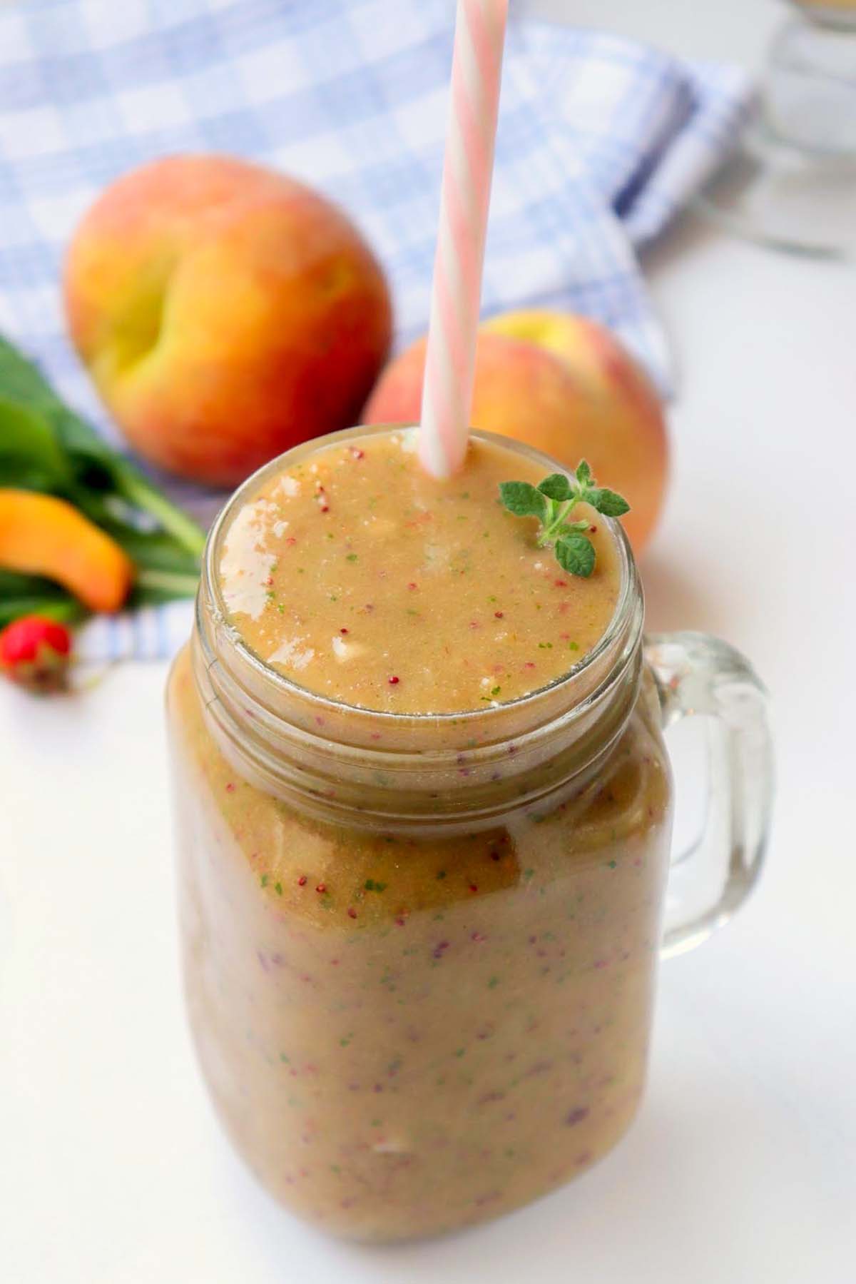 Smoothie in a glass with a pink straw.