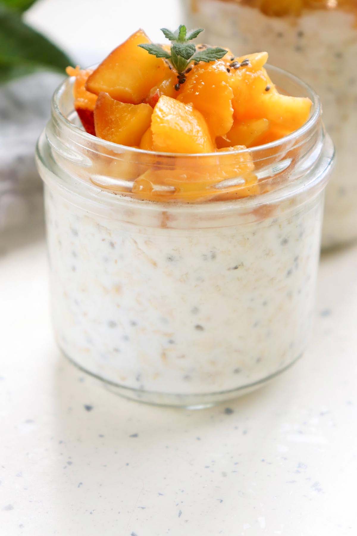 side view jar of peach overnight oats.