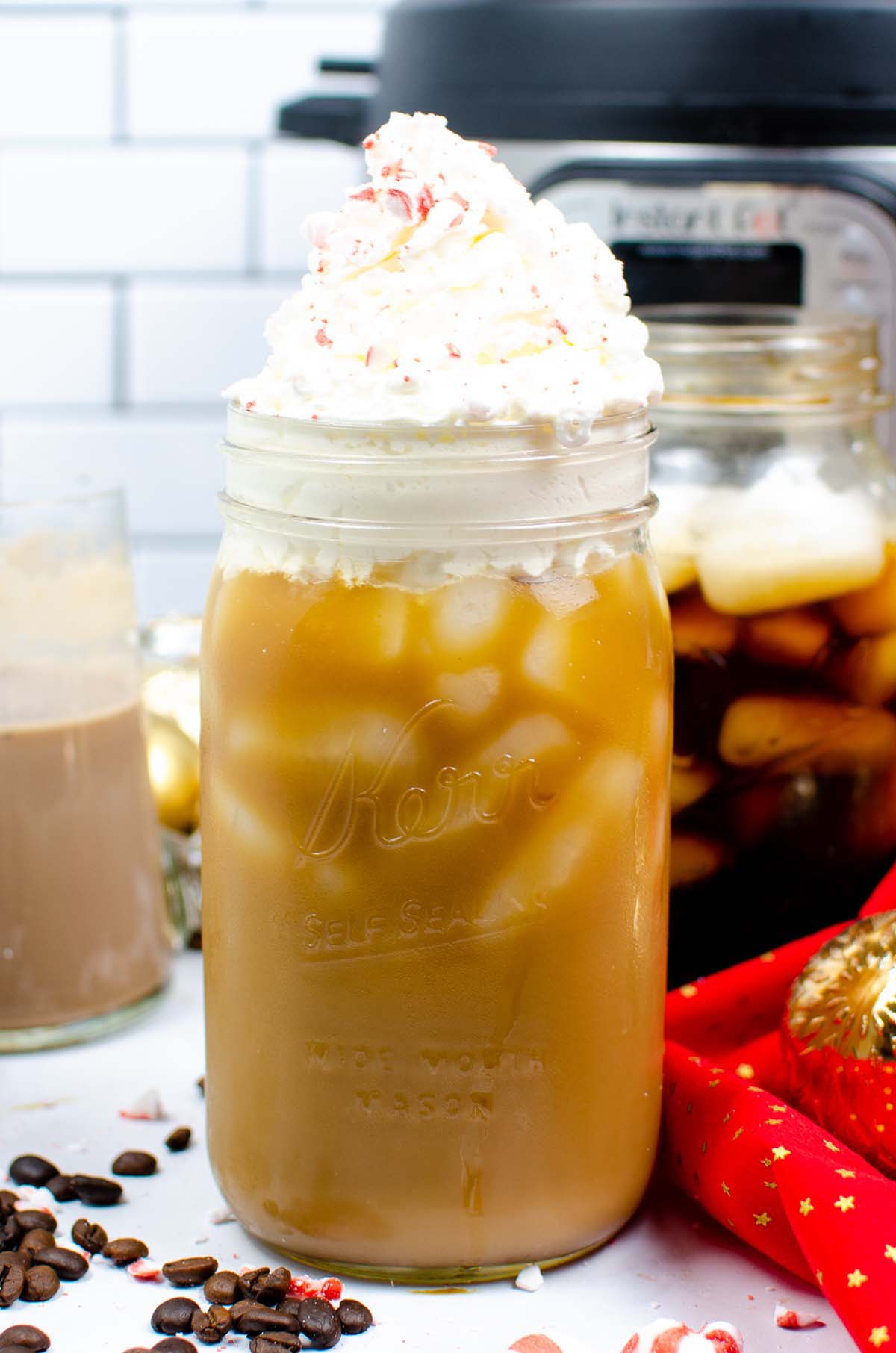 Iced coffee in a glass topped with whipped cream.