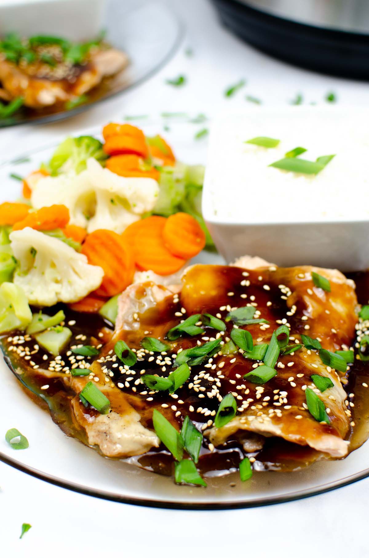 teriyaki salmon, vegetables and rice on a plate.
