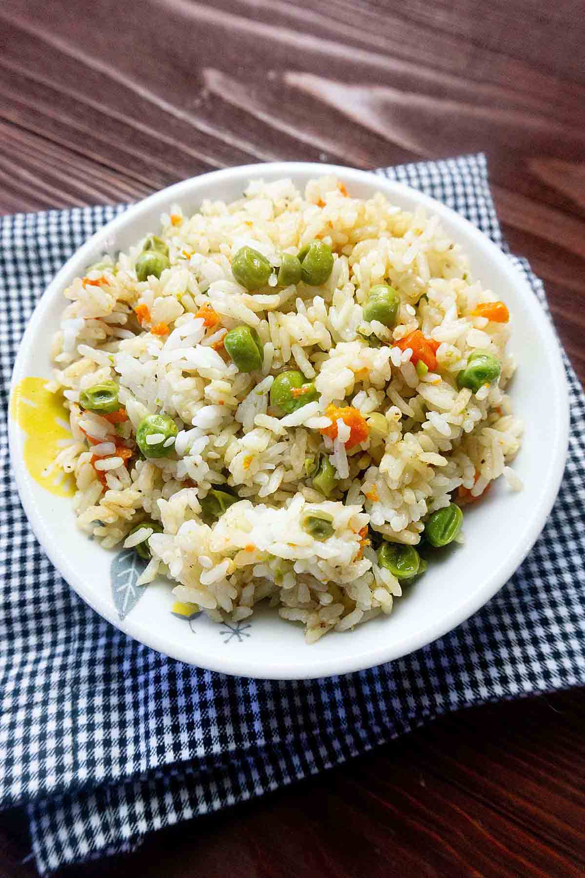 Fried rice in a bowl set on a kitchen towel.