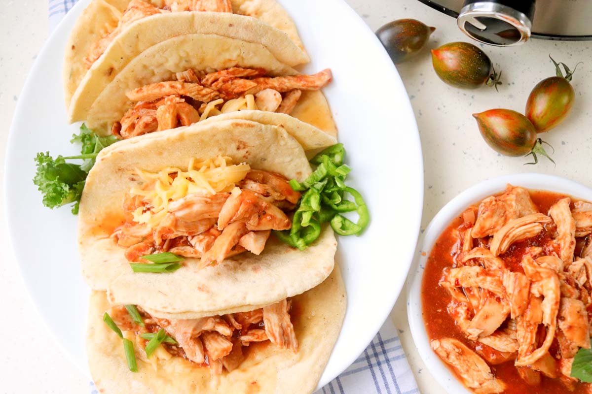 Chicken tacos on a white plate.