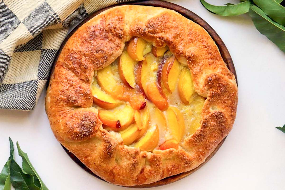 Baked peach galette on a platter.