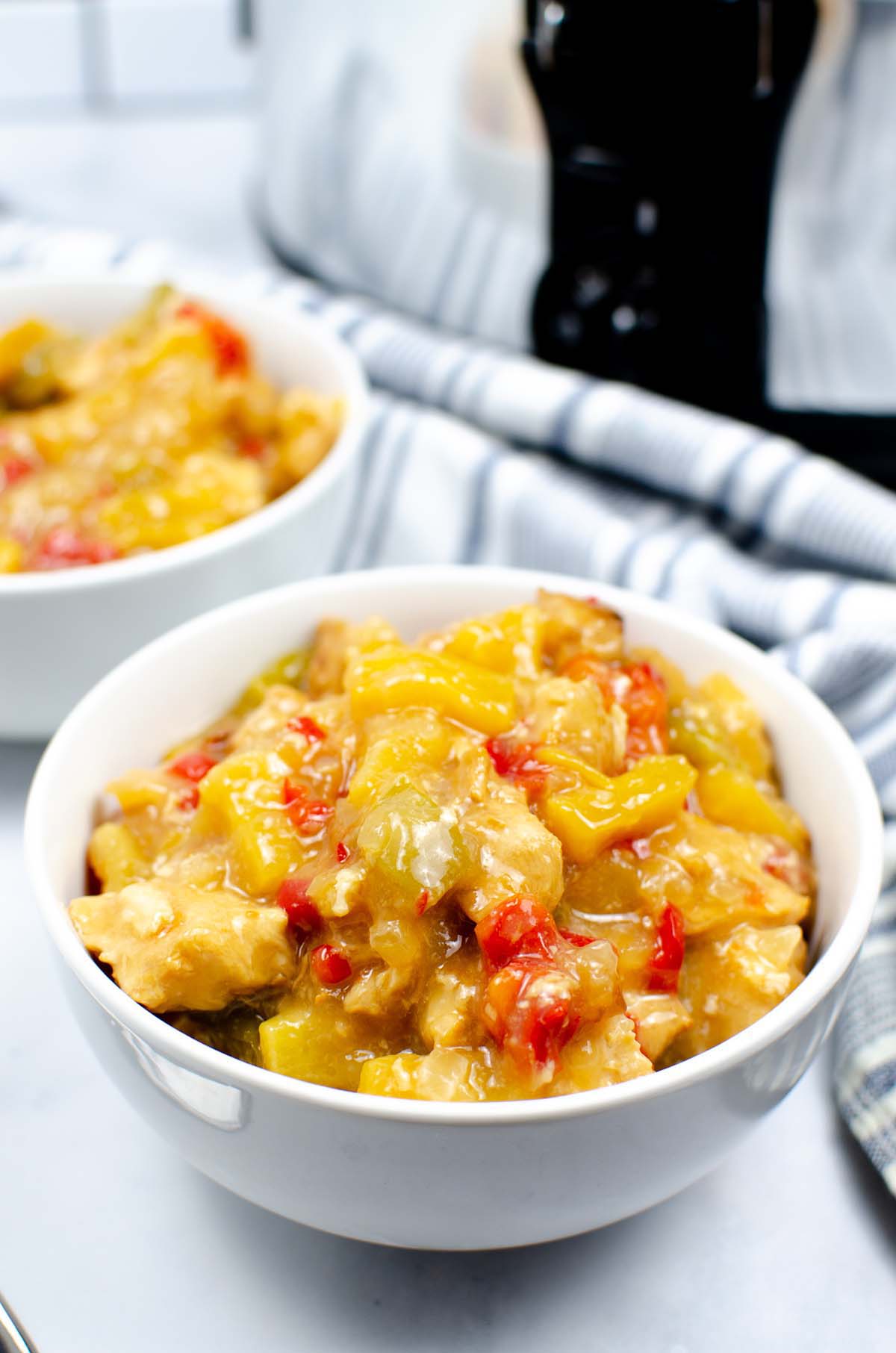 Two bowls of sweet and sour chicken.