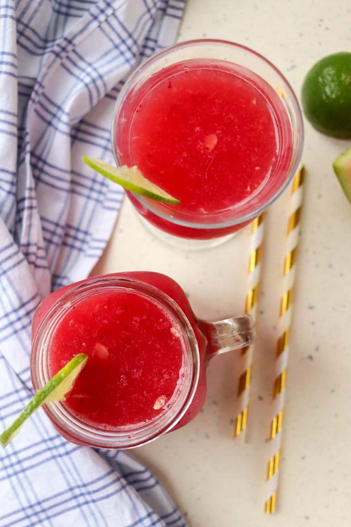 top view of watermelon slushies in glasses with lime wedges.