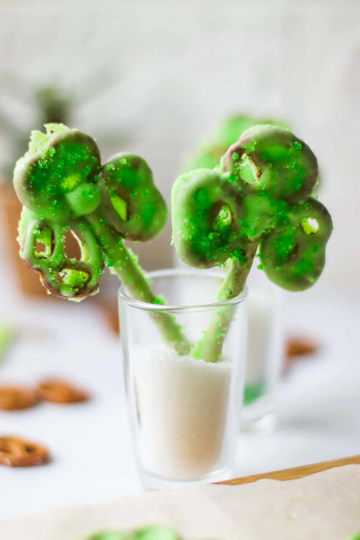 Two shamrock pretzels in a glass.