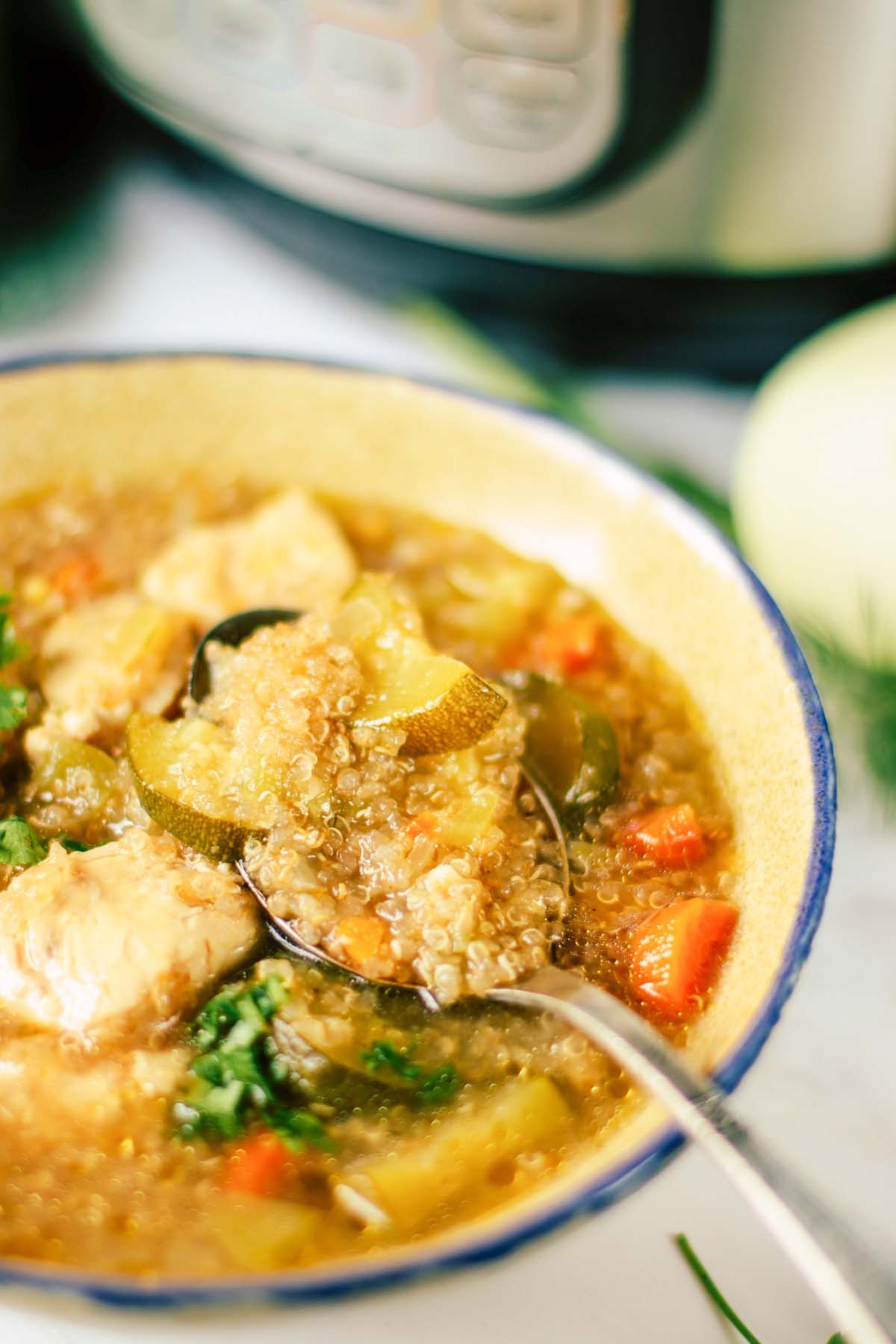 Quinoa soup in a bowl with a spoon.