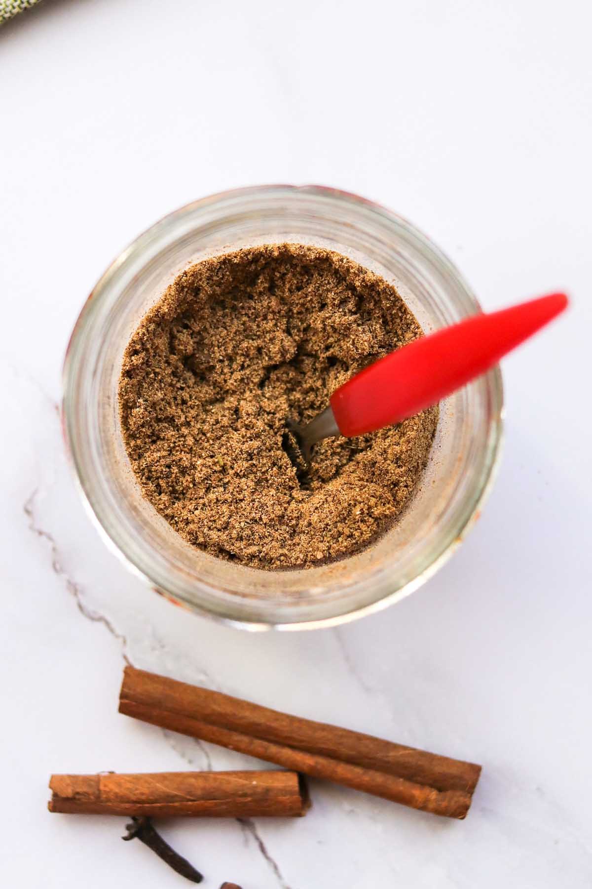 top view of chai spice in a jar with a spoon.