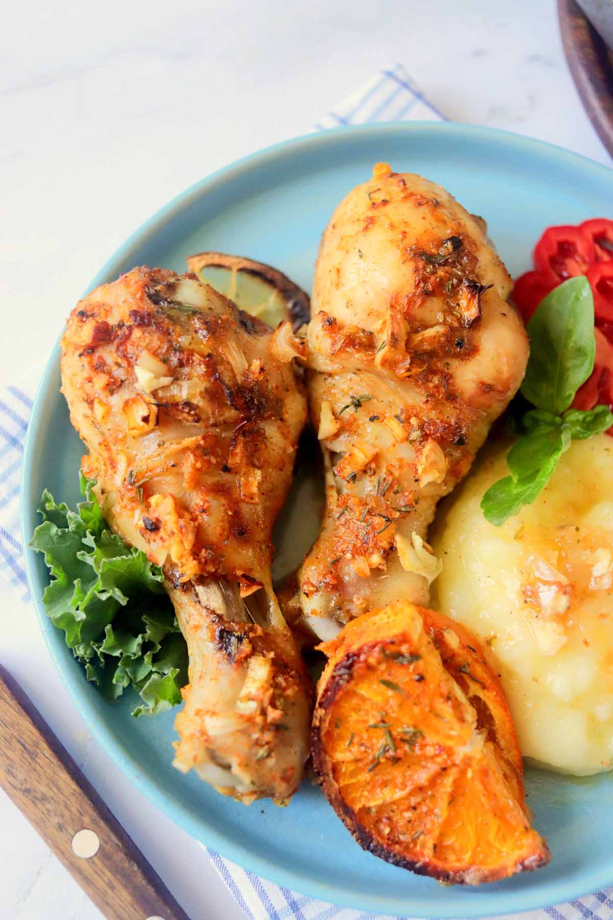 Drumsticks on a plate with mashed potatoes.
