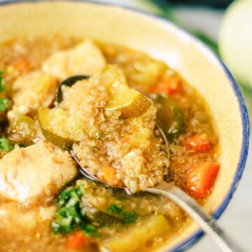 bowl of quinoa soup with a spoon in it.