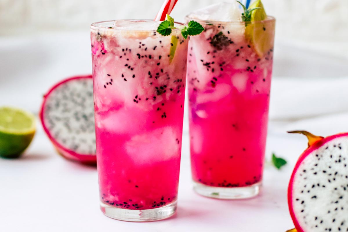 Mocktails in two glasses with lime wedges.