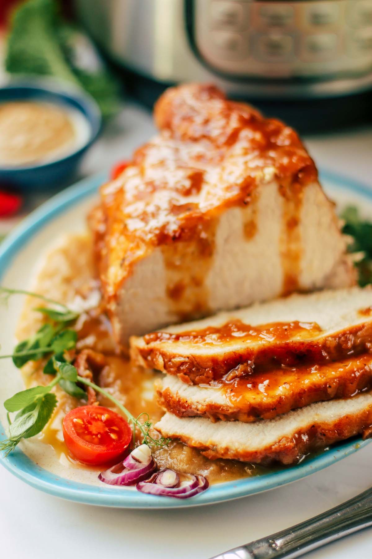 Pork roast on a plate cut into slices.