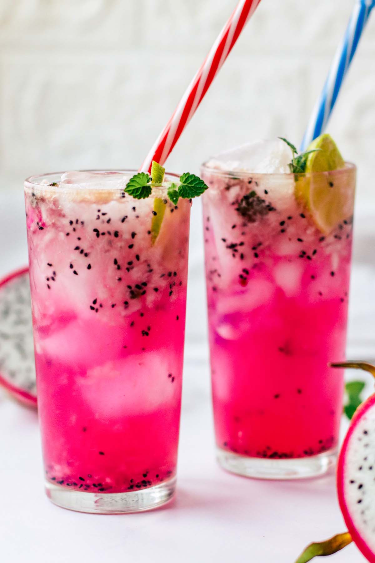 Two glasses of mocktails with straws.