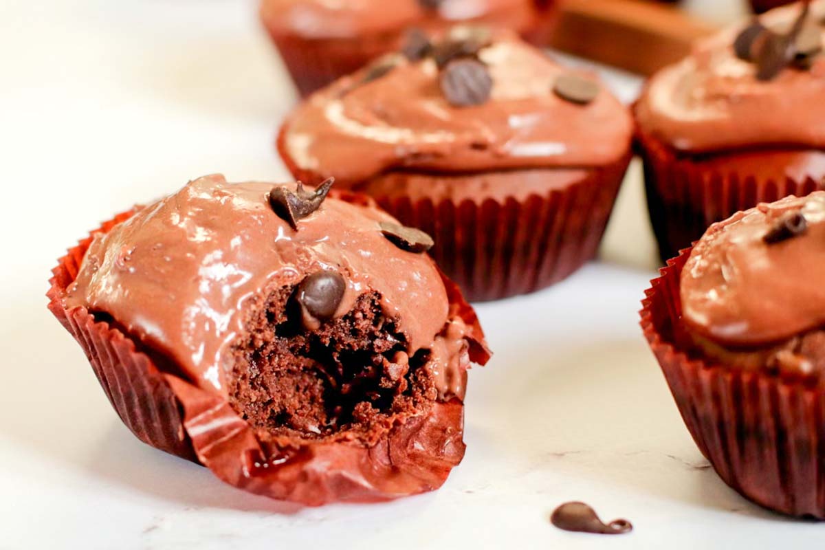 A chocolate cupcake with a bite taken out.