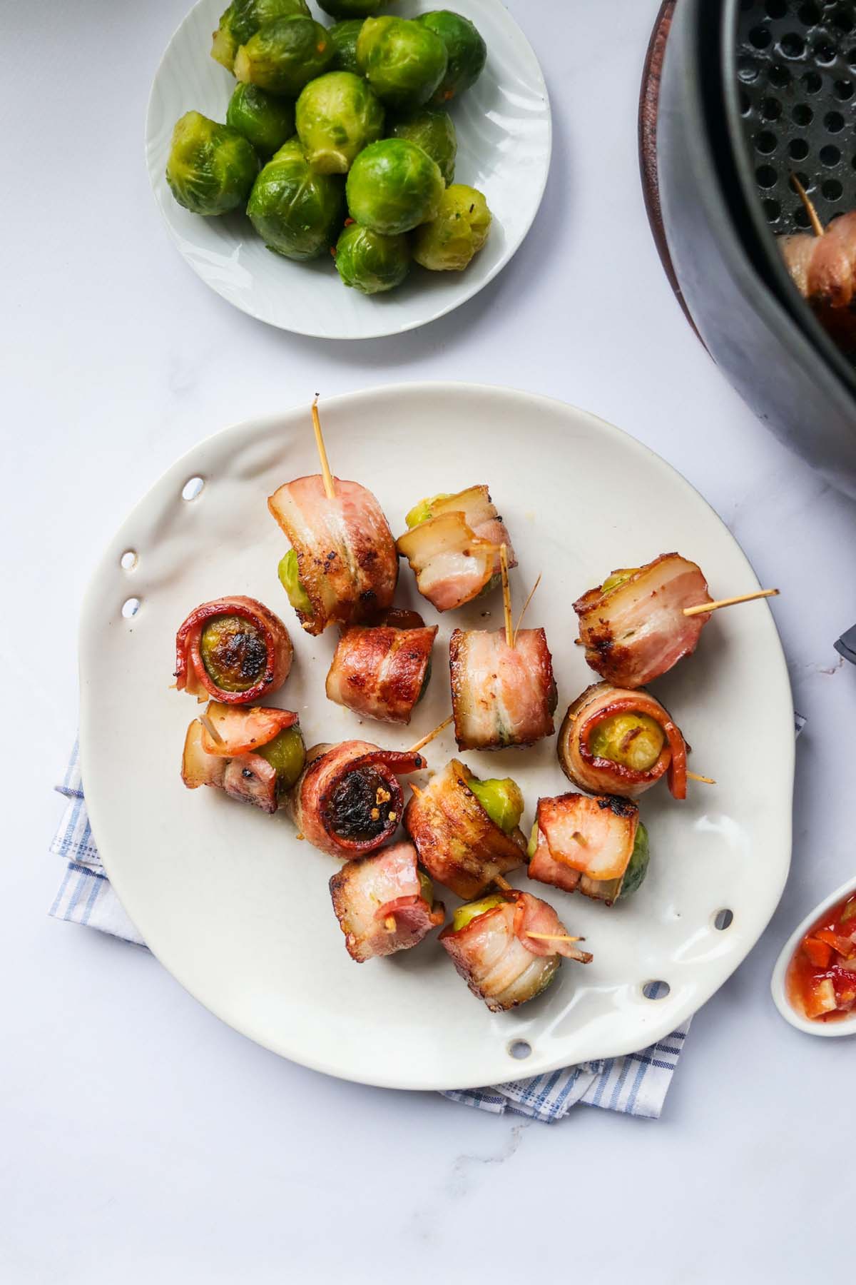 top view of Brussels sprouts wrapped in bacon on a plate.