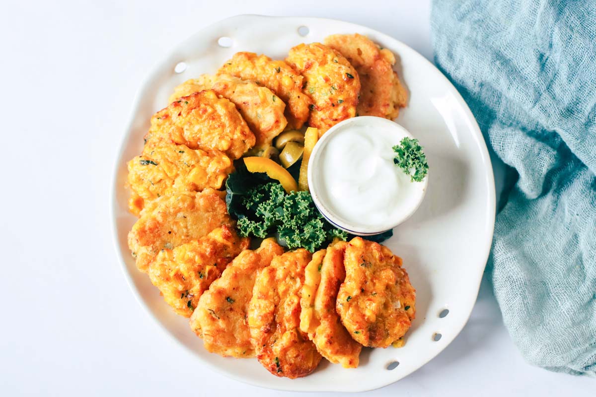 Fritters on a white plate with a white dip.