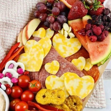 Charcuterie board set on a kitchen towel.