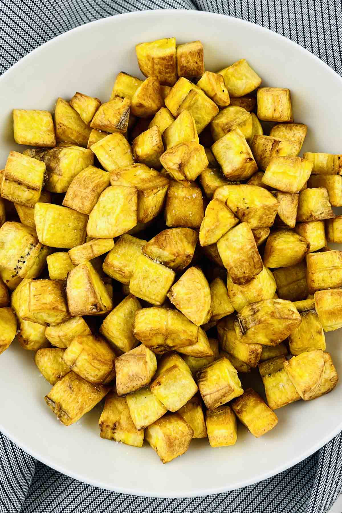 top view of plantain croutons in a white bowl.