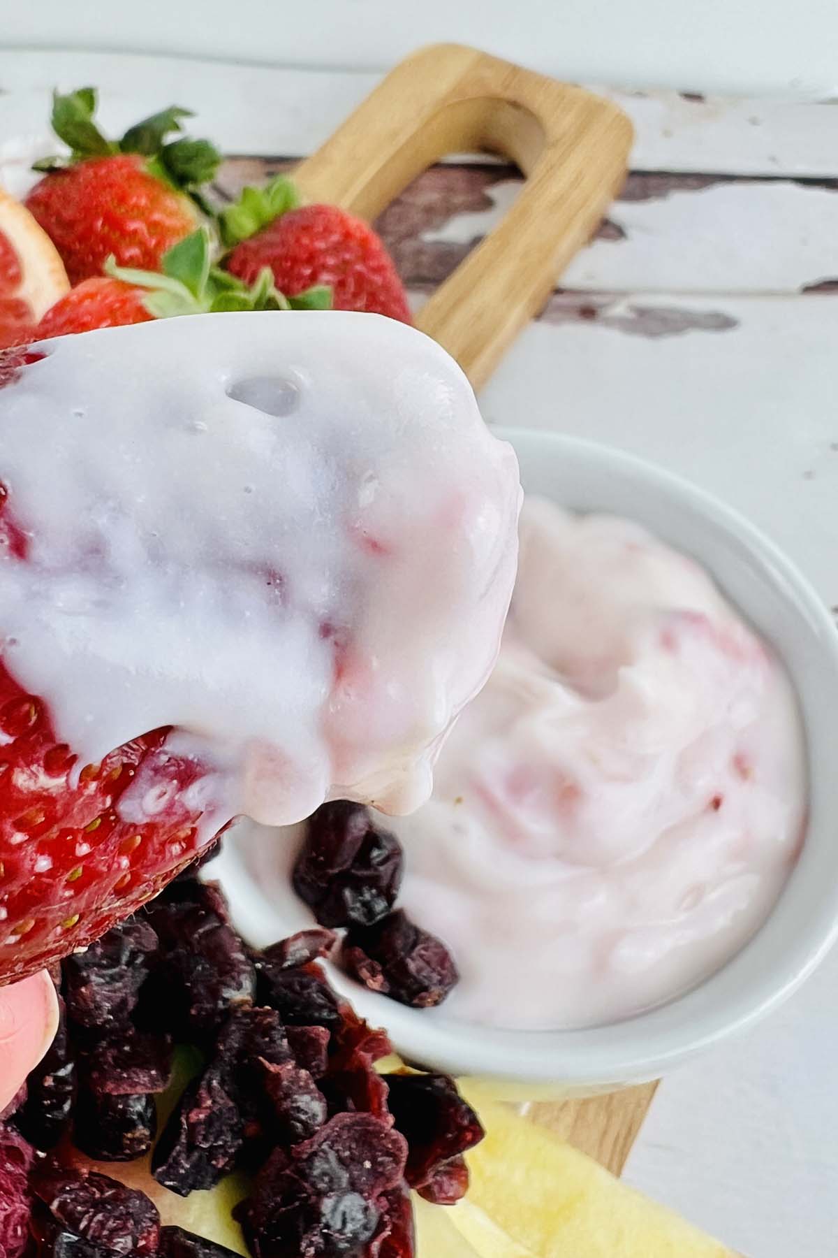 A strawberry scooping yogurt dip.