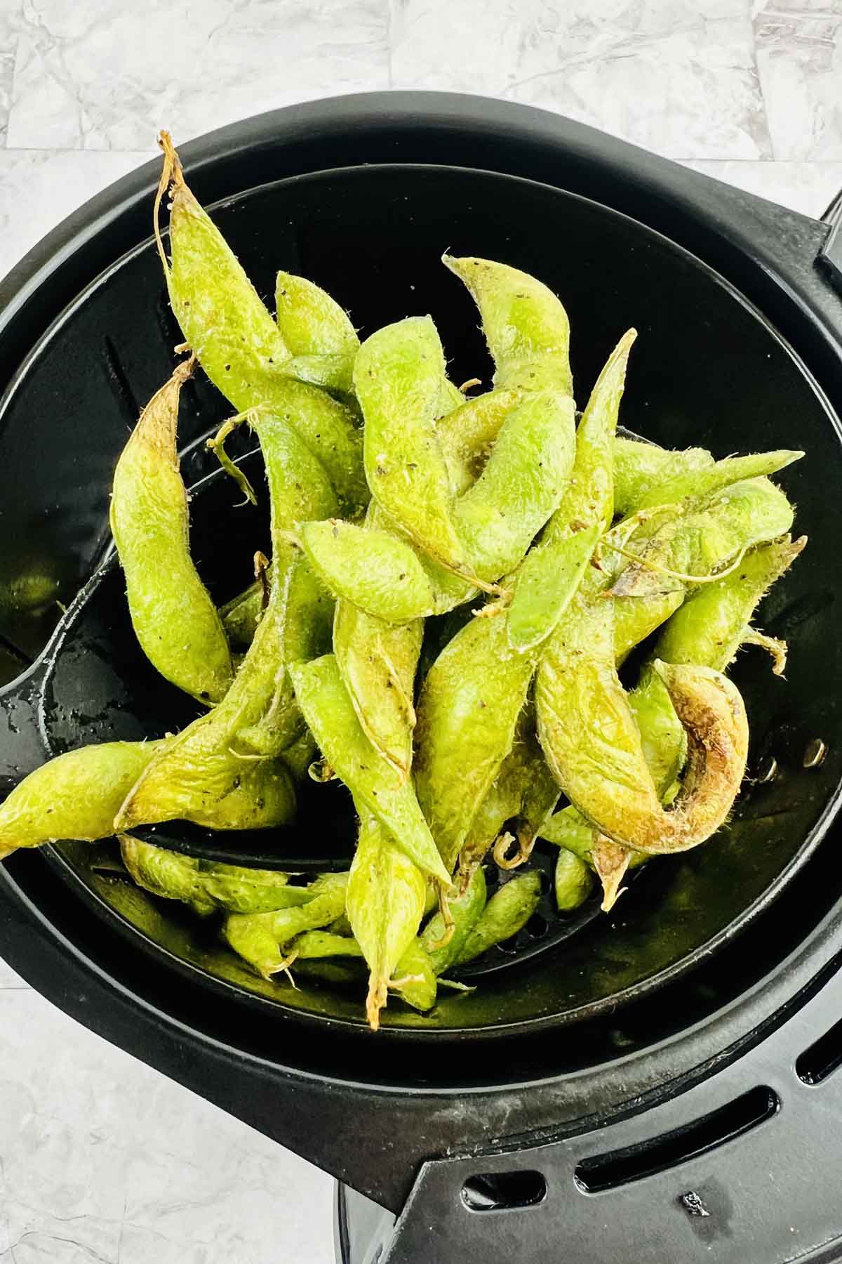 Edamame topped with salt and pepper.
