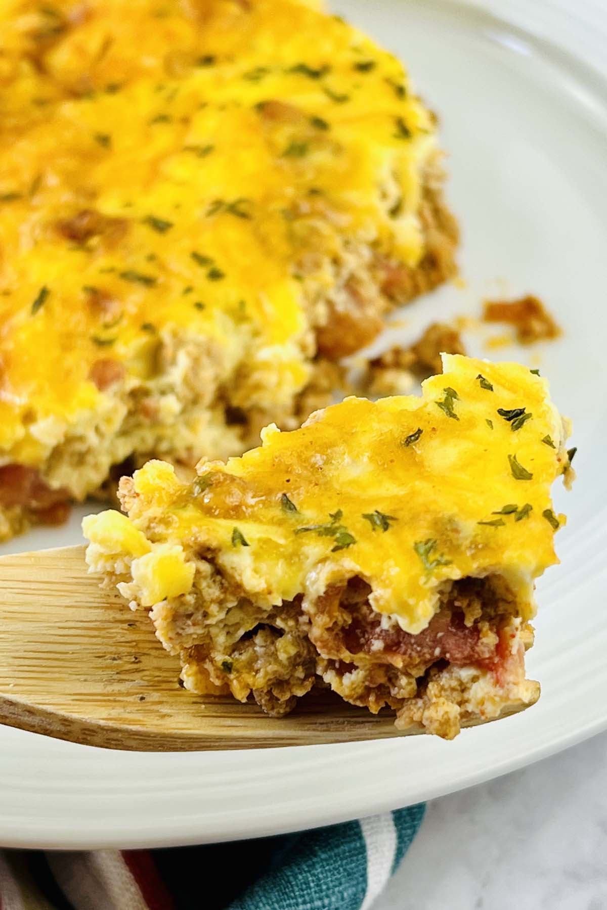 Casserole scooped on a wooden spoon.