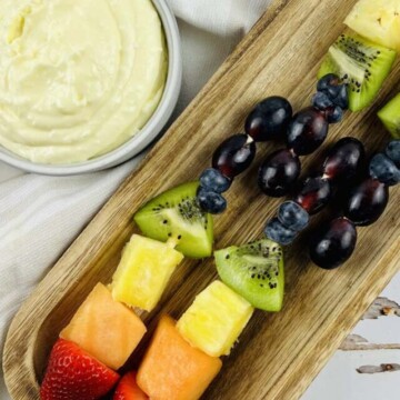 top view of fruit skewers on a wood platter.